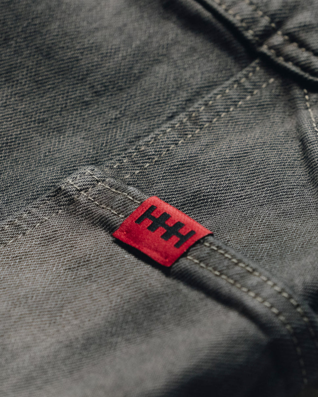 Red label with black text on a gray fabric background