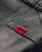 Red label with black text on a gray fabric background