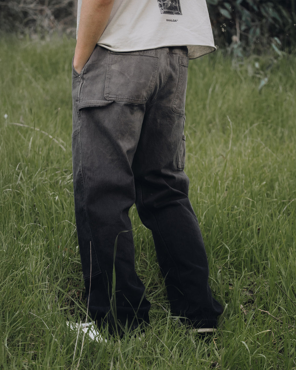 Person wearing dark cargo pants standing in a grassy field
